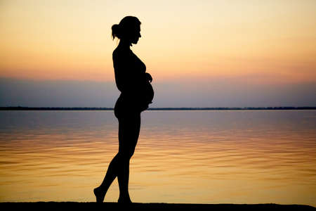 Pregnant woman on beach outdoor. Nature background. Love conceptの写真素材