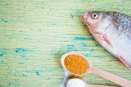 Carp fish over old wooden plank board. Food ingredients