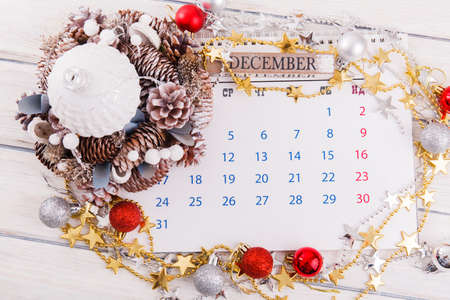 Christmas composition. Christmas gift, knitted blanket, pine cones, fir branches on wooden white background. Flat lay, top view, copy spaceの写真素材