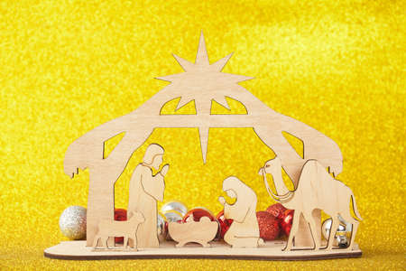 Christmas Nativity Scene of baby Jesus in the manger with Mary and Joseph in silhouette surrounded by the animals and wise men with the city of Bethlehem in the distance with