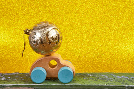 Wood car with christmas decorations. Place for text. Gold backgroundの写真素材