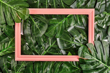 Creative layout made of tropical leaves with vintage frame. Flat lay. Nature concept
