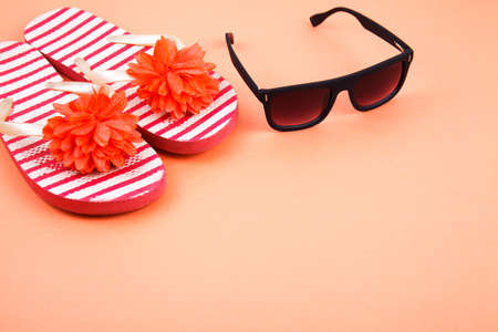 beach accessories on color background - sunglasses, towel. flip-flops and striped hat. summer is...