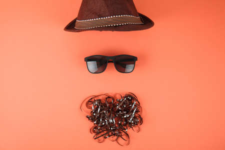 Sunglasses and beard from cassette tape. Summer background. Creative layout