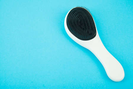 Hairbrush on blue background. Place for textの写真素材