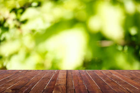 Wood table top on blur abstract green from garden in the morning background.For montage product display or design key visual layoutの写真素材