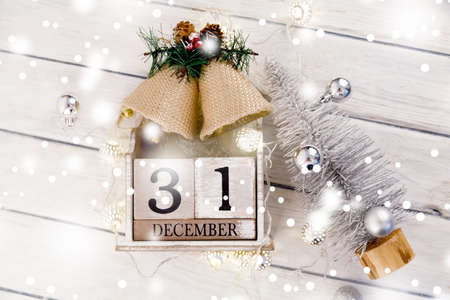 Christmas composition. Christmas gift, knitted blanket, pine cones, fir branches on wooden white background. Flat lay, top view, copy spaceの写真素材