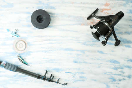 Fishing rod reel on wood background. Equipment close upの写真素材