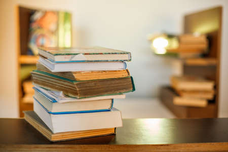 Education concept. Stack of books on table. Blur bookshelf backgroundの写真素材