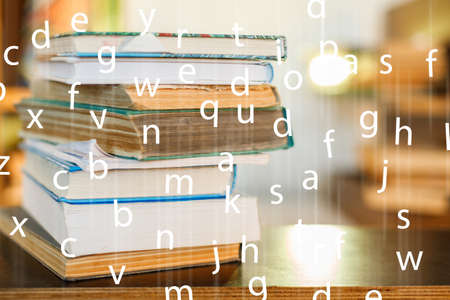 Education concept. Stack of books on table. Blur bookshelf backgroundの写真素材