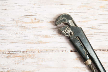 Close up of wrench in wood surface with place for text