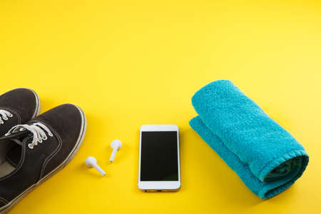 Fitness background with bottle of water, sport shoes on color texture