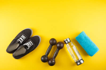 Fitness background with bottle of water, sport shoes on color textureの写真素材