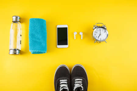 Fitness background with bottle of water, sport shoes on color textureの写真素材