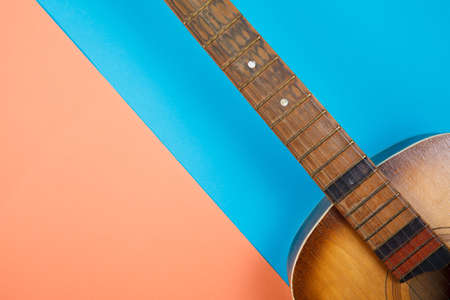 Acoustic guitar resting on color background with copy space. Modern conceptの写真素材