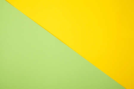Green and yellow pastel color paper geometric flat lay backgroundの写真素材