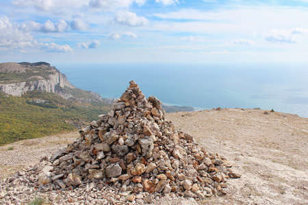 Beautiful landscape from the top of the mountain. The pile of stones against the sky with clouds and...