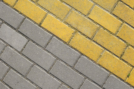 Diagonal gray and yellow paving slabs top view. Bricks as street road, paving stone texture. Abstract dual color paving stone background.の写真素材