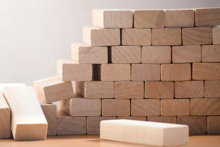 Destroyed wall of light wooden blocks. The concept of broken wall or border.の写真素材