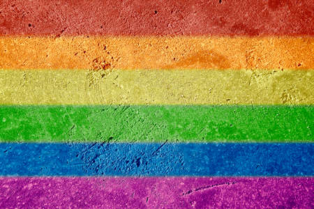 LGBTQ rainbow flag with horizontal stripes painted on stucco wall background. Pride day concept.の写真素材
