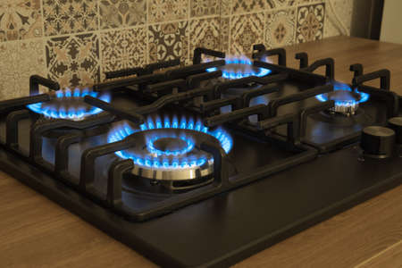 Natural gas burning by blue flames in kitchen stove. Home cooking concept.の写真素材