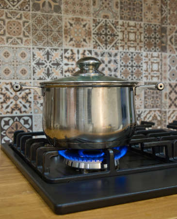 Cooking on a gas stove. The pot on gas burner. Home cooking concept.の写真素材