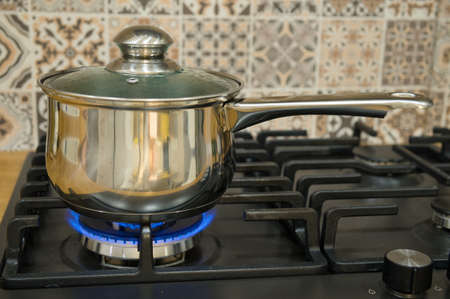 Cooking on a gas stove. The pot on gas burner. Home cooking concept.の写真素材
