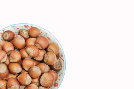 Bowl filled of hazelnuts isolated on white backgrund. Copy space for text.