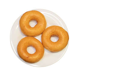 Three classic sweet donuts on plate isolated on white backgroundの写真素材