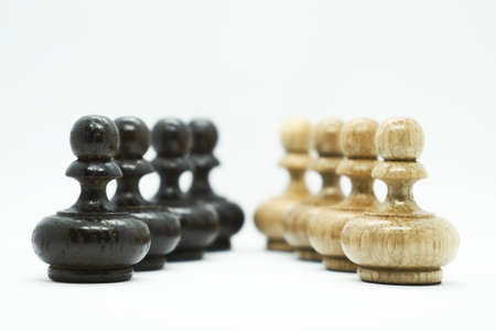 White and black wooden chess pawns in front of each other isolated on white background. Chess game...
