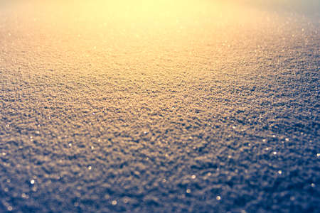 Snow texture in cold night time lighten by the bright orange light. Winter season background. Winter season and snowfall concept.の写真素材