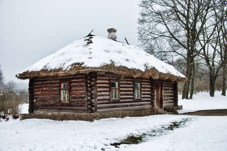 Yasnaya Polyana, Tula Region, Russia - 2021-01-04 - Old traditional russian wooden house izba. Large wooden house with one door and several windows in winter season.のeditorial素材