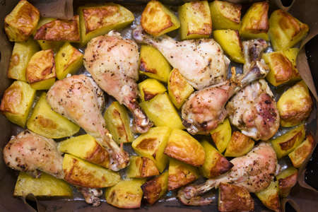 Baked potato and chiken legs. Home cooking concept. Traditional american food.の写真素材