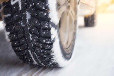 Winter studded tires on snowy road. High speed on winter road. Winter auto race. Blurred motion...