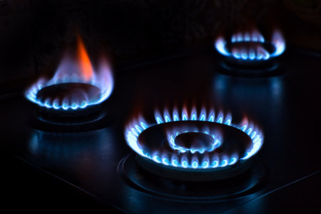 Natural gas burning on the stove. blue flame. three burners. low key and long exposure image. selective focus.の写真素材