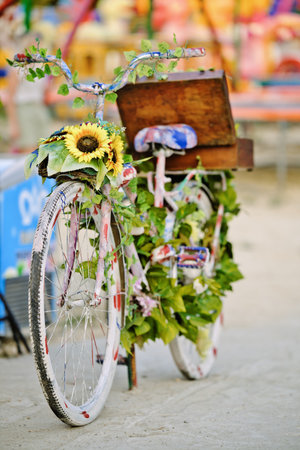 Bicycle decorated with multicolored flowers and leaves in the city.の写真素材