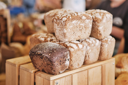 Assorted fresh baked loaves of bread on the market counter.