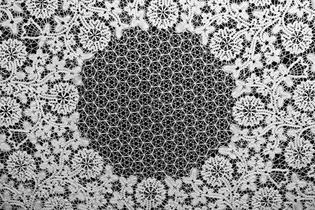 Beautiful white knitted lace on black background. Vintage embroidery pattern.