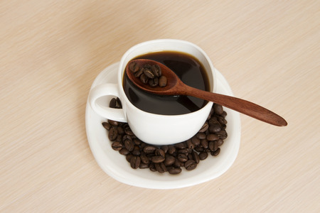 Cup of coffee on a table with a wooden spoonの写真素材