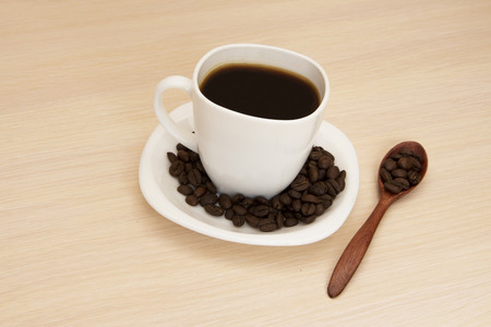 Cup of coffee on a table with a wooden spoonの写真素材