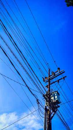 a power lines and wires with blue sky