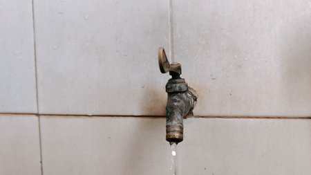 Old faucet with running water in the bathroom, selective focusの写真素材