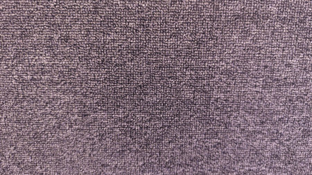 A close-up view of a soft grey carpet showing detailed fiber texture and pattern