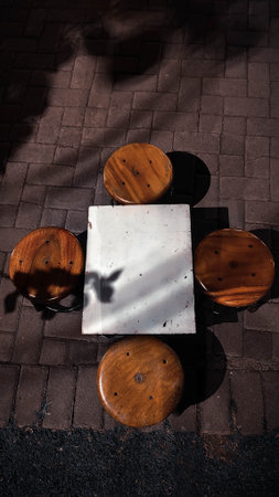 Wooden table and chairs on the street. Shadow from the tree.