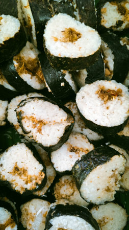 A pile of traditional Indonesian lemper rice rolls wrapped in seaweed