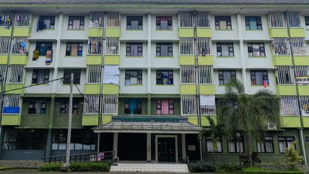 Wide angle shot of a multi-story residential building with green and white color scheme and balconies.のeditorial素材