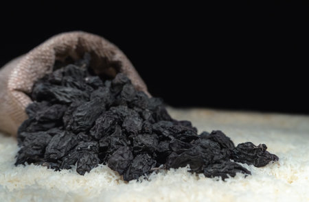 Black raisins on a black background. close-up.