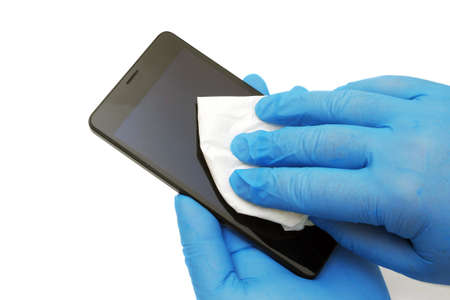 hands in blue medical gloves wiping smartphone isolated on white background