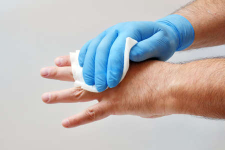 rubbing hand with antiseptic wipe to sterilize it