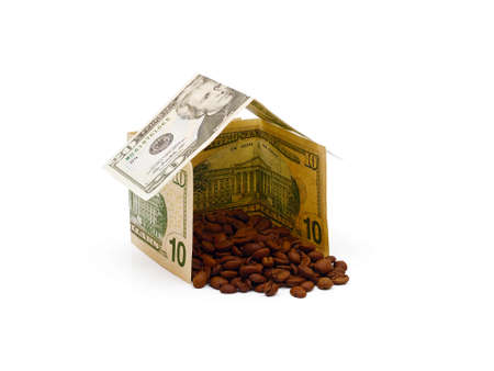 roasted coffee beans in a house made out from dollar banknotes isolated on white backgroundの写真素材